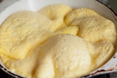 İştah açıcı kahvaltı. Omlet tavada yükseldi.