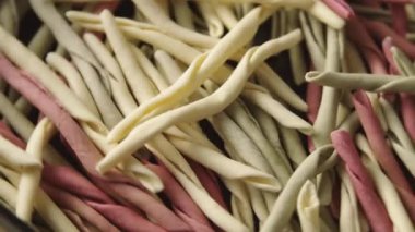 Çeşitli renklerde geleneksel çiğ İtalyan fileja makarna yığını. Makro çekim