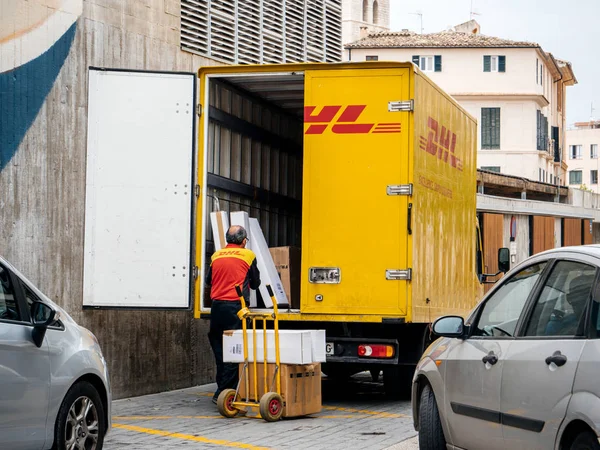 Выгрузка старших работников DHL посылки из грузовика на центральной площади — стоковое фото