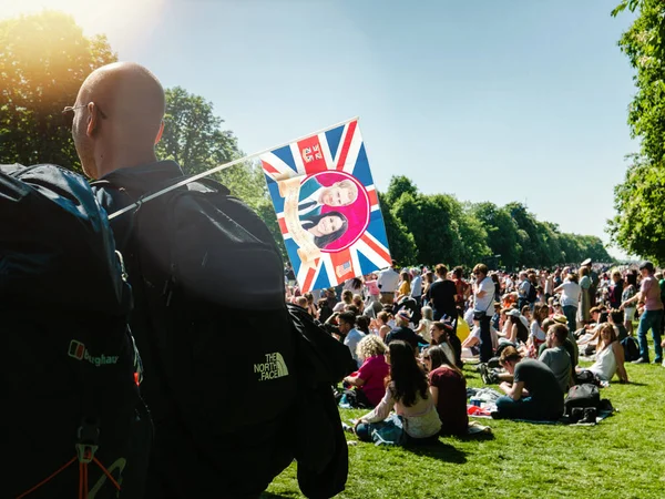 Man with Meghan Markle and Prince Harry flag in green park — Stock Photo, Image