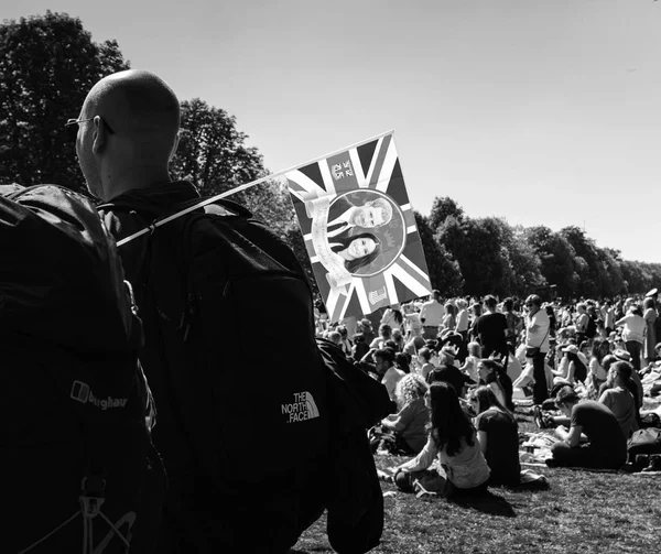 Man with Meghan Markle and Prince Harry flag in green park — Stock Photo, Image