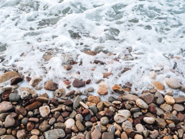 Deniz okyanus dalgaları ile yuvarlak taş plaj ve köpük dalgalar, yukarıdan görüntülemek