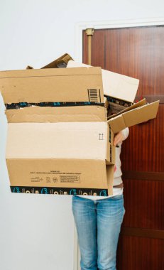 Amazon Prime paketleri yığını tutan kadın