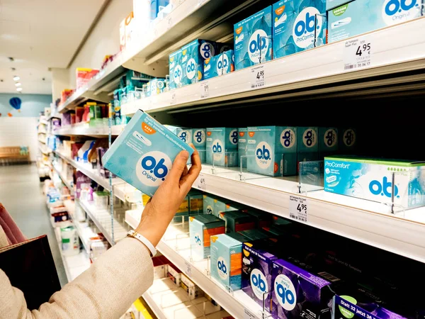 Woman hand taking from shelves a package of OB tampons — Stock Photo, Image