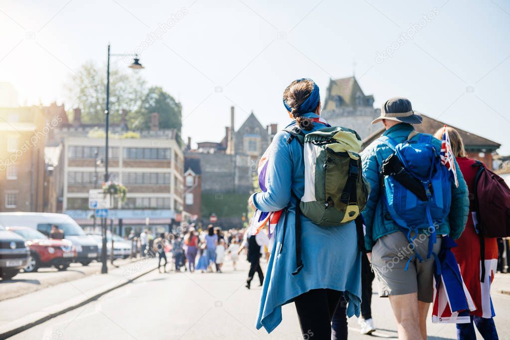 Defocused view of unrecognizable travelers walking to royal wedding marriage celebration of Prince Harry and Meghan Markle to Windsor Castl