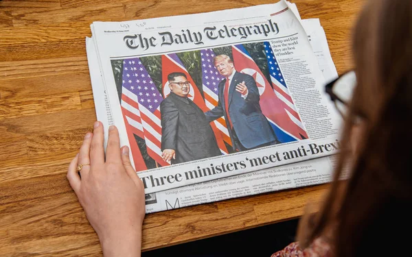 Mujer leyendo sobre reunión Kim-Trump — Foto de Stock