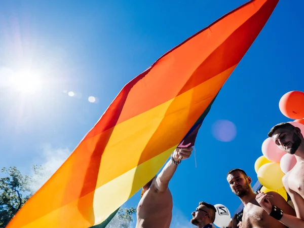 Gay orgoglio gli uomini danza LGBT persone su camion con arcobaleno bandiera — Foto Stock