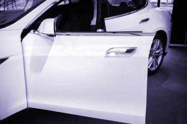 Paris, Fransa - 29 Kasım 2014: Yeni beyaz Tesla Model S elektrikli otomobil ayrıntı açık sürücü kapı - mavi renk saçılması