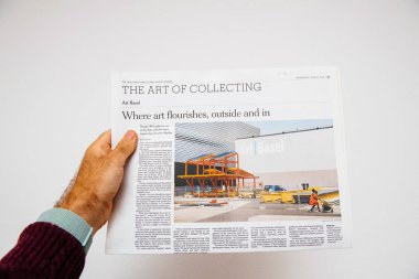 Paris, Fransa - 13 Haziran 2018: Basel, İsviçre Art Basel Modern sanat sergisi hakkında New York Times gazetesi gazete tutan adam