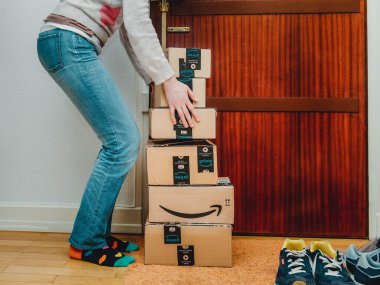 Paris, Fransa - 13 Ocak 2018: kapının yanında ağır kutuları Asansör çalışan bir ev kapı kadına teslim Amazon Prime yığın paketleri