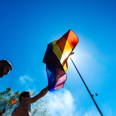 Strasbourg, Fransa - 10 Haziran 2017: gurur mavi gökyüzüne karşı eşcinsel gökkuşağı bayrağı sallayarak kare görüntü insanlar