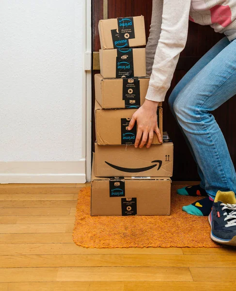 Paris, Fransa - 13 Ocak 2018: birden fazla Amazon karton ana kutu kadın tarafından parsel teslim kurye tarafından teslim sonra kaldırdı