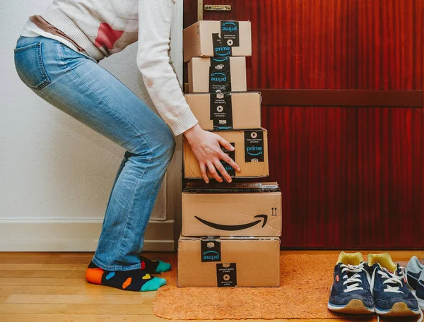 Paris, Fransa - 13 Ocak 2018: kadın ağır ev kapıya teslim Amazon Prime paketleri yığını kaldırma