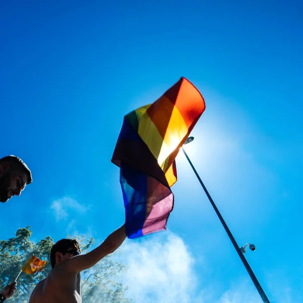 Strasbourg, Fransa - 10 Haziran 2017: gurur mavi gökyüzüne karşı eşcinsel gökkuşağı bayrağı sallayarak kare görüntü insanlar