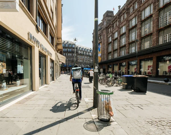 Vista trasera del hombre conduciendo entrega bicicleta pedaleando rápido — Foto de Stock