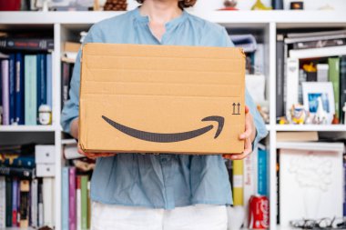 Paris, Fransa - 4 Temmuz 2018: holding tanıtım teslim Amazon Prime paketi unboxing, gururlu Amazon Prime istemci - Amazon logosu ile yapmaya hazırlanıyor gösterilen kadın