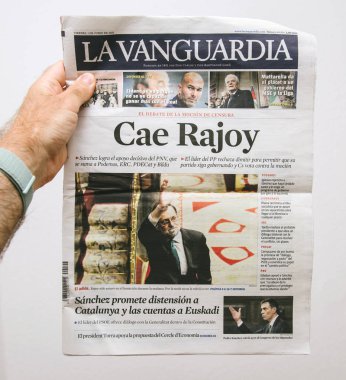 BARCELONA, SPAIN - JUNE 6 2018: Man holding La Vanguardia newspaper cover with Cae Rajoy translated as Mariano Rajoy goodbye when a vote of no confidence ousted his government clipart