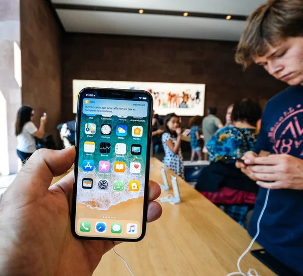 Мужчина держит смартфон iPhone X в Apple Store — стоковое фото