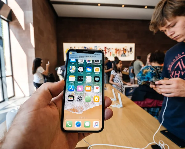 Mann hält iPhone und Smartphone in Apple-Geschäft — Stockfoto