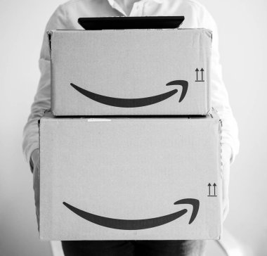 Logo ile birden çok Amazopn kutusu tutan gülümseyen kadın