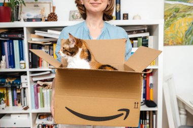 Paris, Fransa - 4 Temmuz 2018: Kadın unboxing karton ile kedi içinde - e-alışveriş Amazon sitesinden yeni teslim