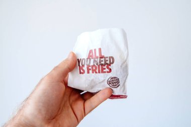 Paris, Fransa - 5 Haziran 2018: Burger King kağıt torba tek ihtiyacınız ile patates kızartması ve Burger King logo beyaz Bankamatik karşı adam elinde olduğunu. Hamburger fast food küresel zinciri Burger King olsun