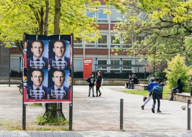 STRASBOURG, FRANCE - MAY 5, 2018: Emmanuel Macron, candidate to the Presidency of France poster on a dedicated campaign agitation area in front of French School Lyceum clipart