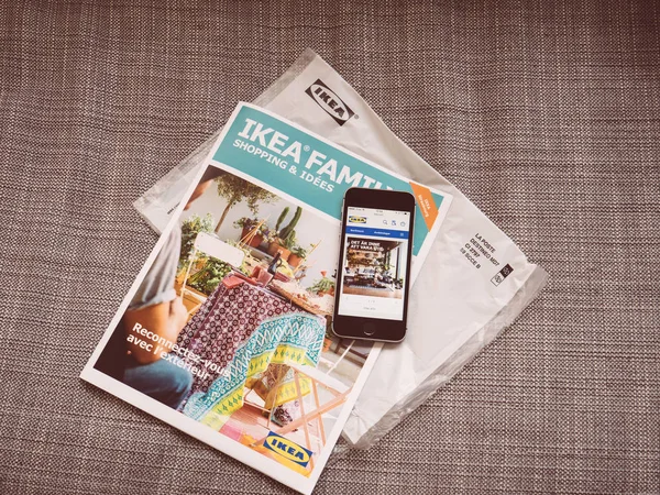 Ikea family Monatskatalog und Smartphone mit Ikea-Website — Stockfoto