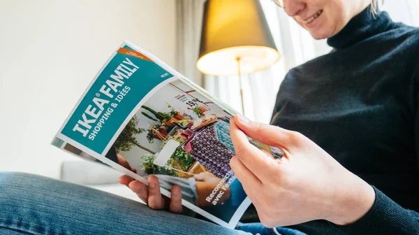 PARIS, FRANCE - MAY 3, 2017: Curious elegant woman reading IKEA catalogue furniture choosing for her new house — Stock Image Paris France May 2017 Curious Elegant Woman Reading Ikea Catalogue Royalty Free Stock Photos