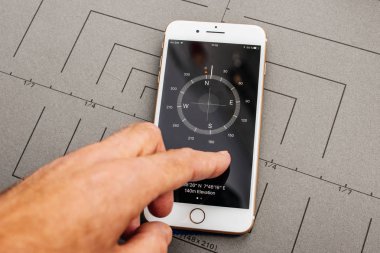 Paris, Fransa - Eyl 26, 2016: Erkek el yeni Apple iphone 7 8 tutan artı sonra unboxing ve app uygulama yazılımı, pusula app yükleyerek test
