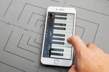 Paris, Fransa - Eyl 26, 2016: Yeni Apple iphone 7 8 tutarak artı sonra unboxing ve app uygulama yazılımı App Garageband yükleyerek test erkek el