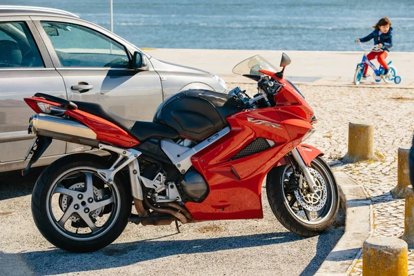 Lisbon, Portekiz - 10 Şubat 2018: Yan görünüm trendy Honda Vfr moto modern motosiklet kırmızı renk şehir güneş ışığında sokak Park