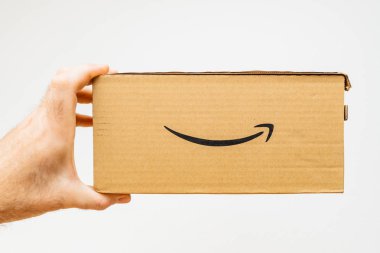 Paris, Fransa - 5 Şubat 2018: Amazon Premium Prime karton kutu beyaz arka planı unboxing önce tutan adam