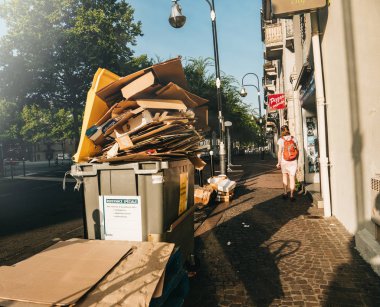 Chambery, Fransa - Aug16, 2018: Fransızca Chambery dumpsters kağıt karton kutuları çöp kadın yakın yürüyüş ile dolu olmak ile sokakta