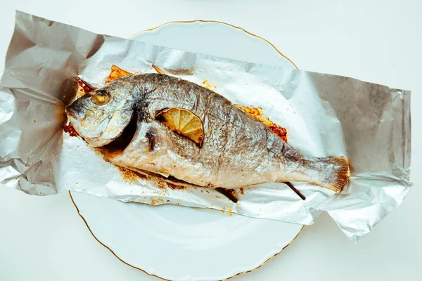 Two gilt-head bream fish on the aluminum foil — Stock Photo, Image