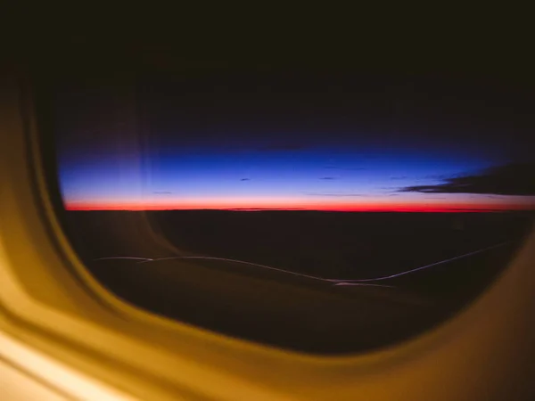 Σύννεφα στο ηλιοβασίλεμα μέσα από το παράθυρο αεροπλάνο — Φωτογραφία Αρχείου