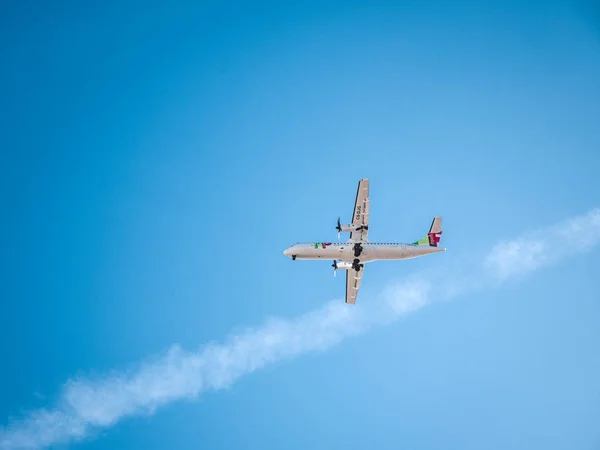 Летающий самолет в голубом небе — стоковое фото