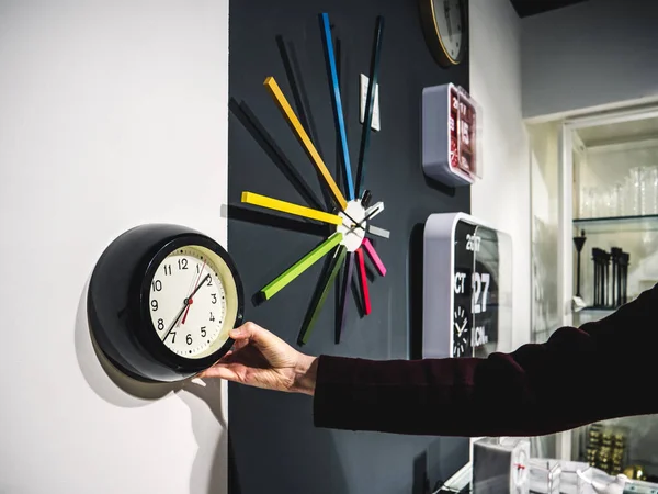 Gröda kvinna att välja klocka på väggen — Stockfoto