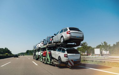 Almanya - 11 Mayıs 2018: Skoda Octavia ve Skoda Superb yeni araçların taşıma ve güneş ışığı mavi gökyüzü altında karayolu üzerinde sürme uzun kamyon görünümünü