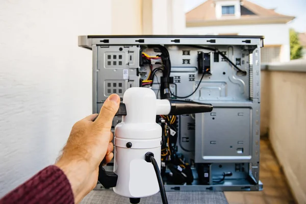 Crop man cleaning computer with vacuum pump — Stock Photo, Image