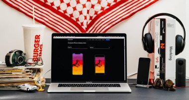 Londra, İngiltere - 13 Eylül, 2018: Safari tarayıcı ile yaratıcı oda masaya Macbook Pro dizüstü vitrine Apple bilgisayarlar Web sitesi en son iphone Xr smartphone ile karşılaştırmak iphone boyutu