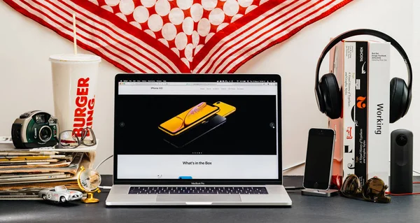 2018年9月13日 创意室表与 Safari 浏览器在 Macbook Pro 笔记本电脑展示苹果电脑网站最新的 Iphone 智能手机与黄色电话盒子里是什么 — 图库照片