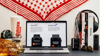 Londra, İngiltere - 13 Eylül, 2018: Yaratıcı oda masaya Macbook Pro dizüstü Apple bilgisayarlar Web sitesi en son Apple Watch serisi 4 düşüş algılama ile vitrine Safari tarayıcı ile acil durum sos