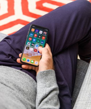 Londra, İngiltere - 21 Eylül, 2018: app uygulama ana ekran üzerinde seyir büyük Oled retina ekran ve a12 biyonik çip ile yeni Apple iphone Xs kullanan adam