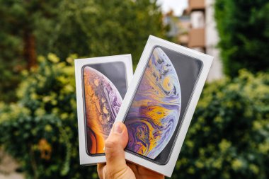Paris, Fransa - 21 Eylül, 2018: Gururlu adam müşteri yeni en son iphone Xs ve Xs Max akıllı telefonlar yeşil arka planı unboxing önce karşılaştırma Pov