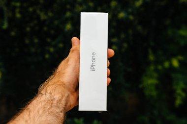 Paris, Fransa - 21 Eylül, 2018: Gururlu adam müşteri karşılaştırıldığında yeni en son iphone Xs Max smartphone telefon yeşil arka plan - logo ve marka kutusuyla yan görünüm unboxing önce Pov