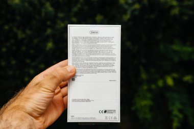 Paris, Fransa - 21 Eylül, 2018: Gururlu adam müşteri yeni en son iphone Xs smartphone karşılaştırma Pov telefon yeşil arka plan - logo ve marka kutusuyla yan görünüm unboxing önce