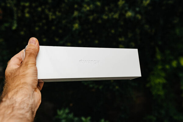 ПАРИЖ, Франция - 21 сентября 2018 года: Гордый владелец нового золотого издания Apple Computers Watch Series 4 носимое устройство, держащее белый картон на зеленом фоне города
