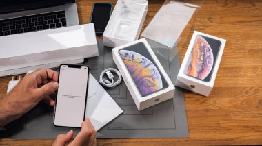 PARIS, FRANCE - SEPTEMBER 21, 2018 Apple fan boy unboxing latest new Apple Iphone Xs Max and Xs flagship smartphone mobile phone model from Apple Computers it may take some time to activate your phone clipart