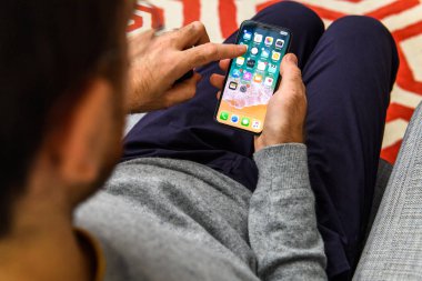 Londra, İngiltere - 21 Eylül, 2018: yeni Apple iphone kullanan adam Xs ile büyük Oled retina ekran ve a12 biyonik çip, app uygulaması seyir silmek apps ekranından
